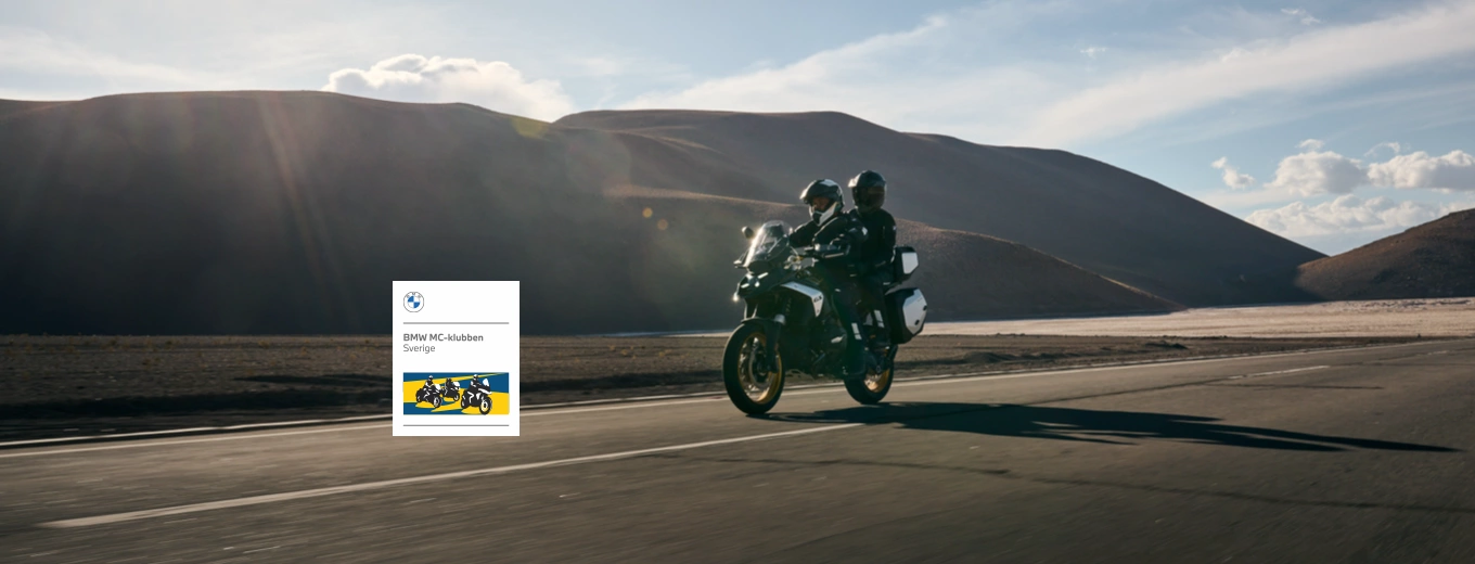 Motorcyklister kör på landsväg. BMW-klubbens logga i förgrunden.