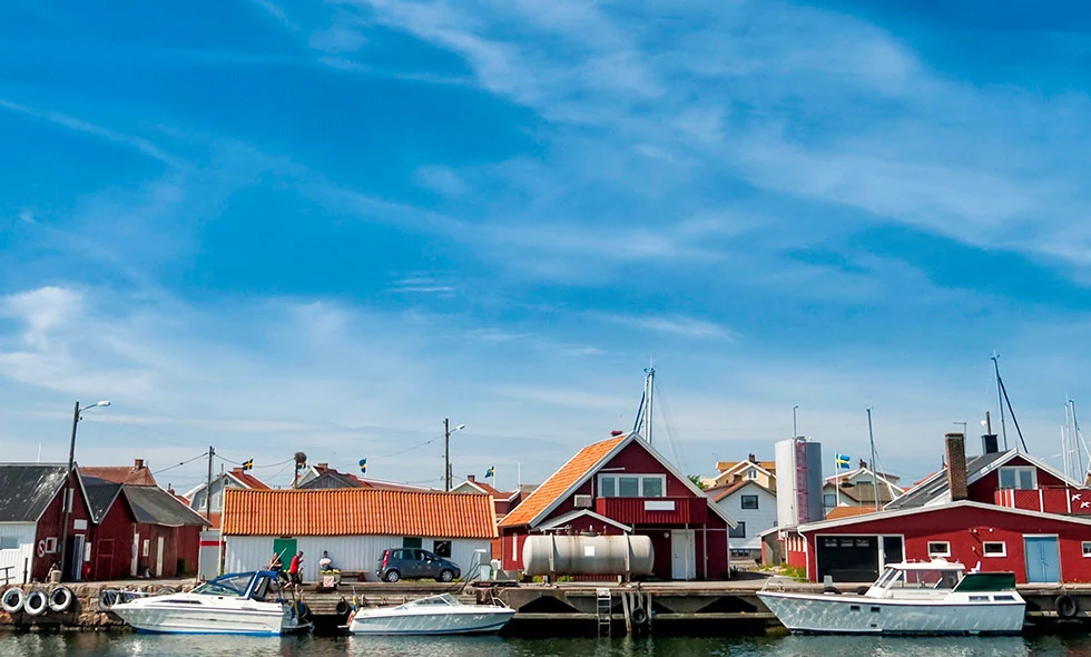 Båtar i hamn med fiskebodar i bakgrunden