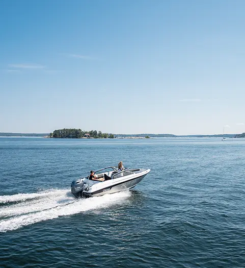 Motorbåt med metallskrov åker över öppet hav en solig sommardag