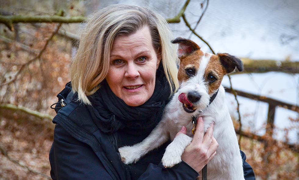 Kvinna håller om glad Jack Russell Terrier