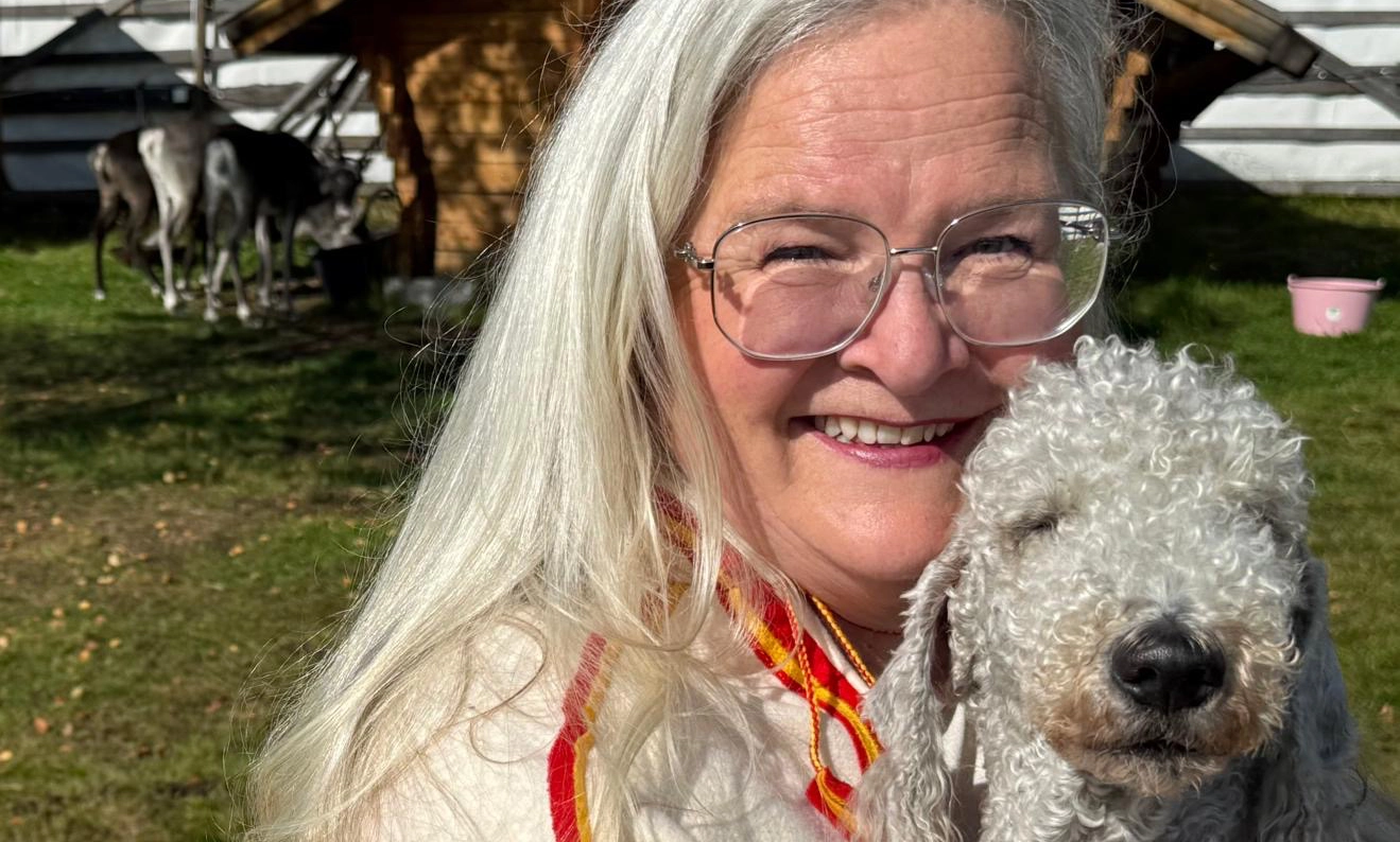 Glad hundägare håller sin Bedlington terrier-hund