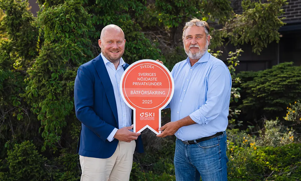 Svedeas vd Jonas Roberts och Göran Södergren, affärsansvarig båt och vattenskoter, står utomhus i naturen, hållandes en medalj som visar att Svedea har Sveriges nöjdaste privatkunder inom båtförsäkring.