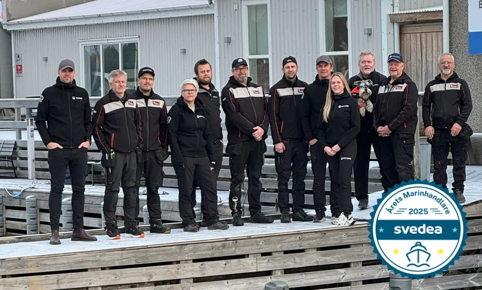 Gruppbild av personal på brygga, med en badge i hörnet för utmärkelsen "Årets marinhandlare 2025" utfärdad av Svedea.)