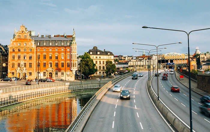 Motorväg med bilar som kör nära vattnet i centrala Stockholm.)