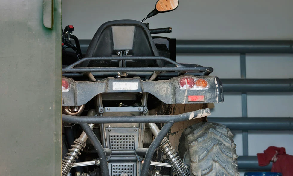 En smutsig ATV parkerad i ett garage