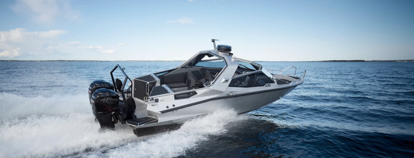 Motorbåt av märket Anytec med dubbla utombordsmotorer färdas snabbt över ett öppet hav under en blå himmel.