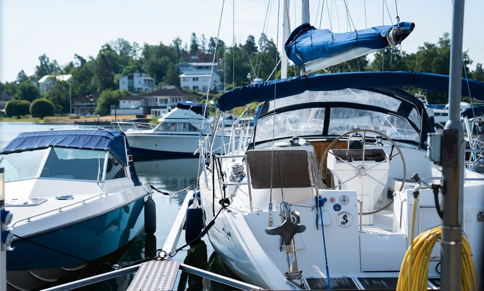 Två båtar vid en brygga, en motorbåt och en segelbåt.