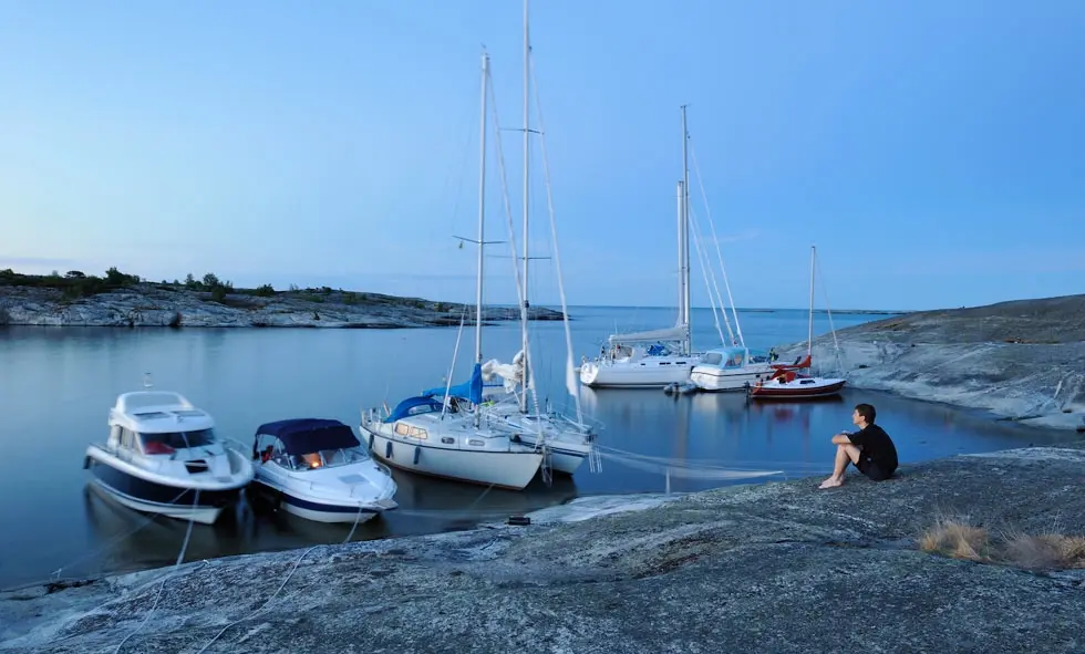 Vita båtar förtöjda i en naturhamn.