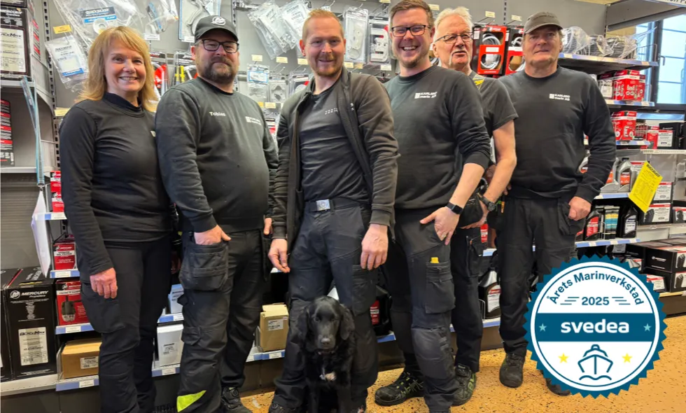 Gruppbild av personal i verkstadslokal, med en badge i hörnet för utmärkelsen "Årets marinverkstad 2025" utfärdad av Svedea.)