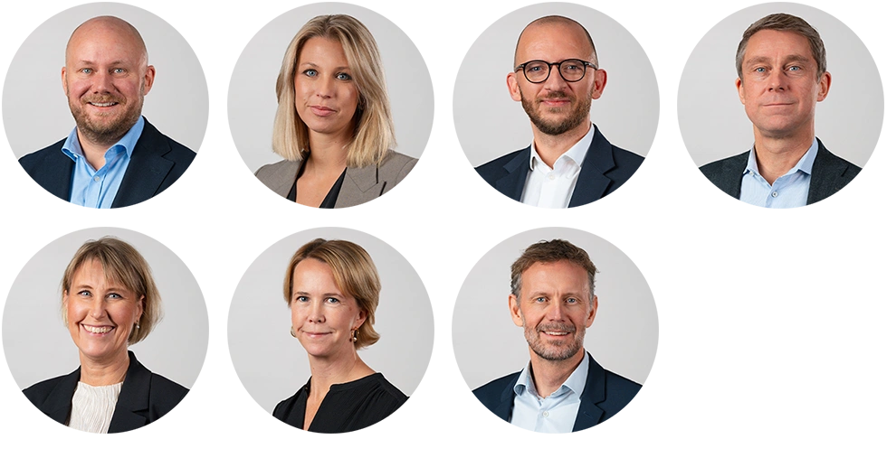 Ledningsgrupp med sju personer fotograferade i studio mot ljus bakgrund.)