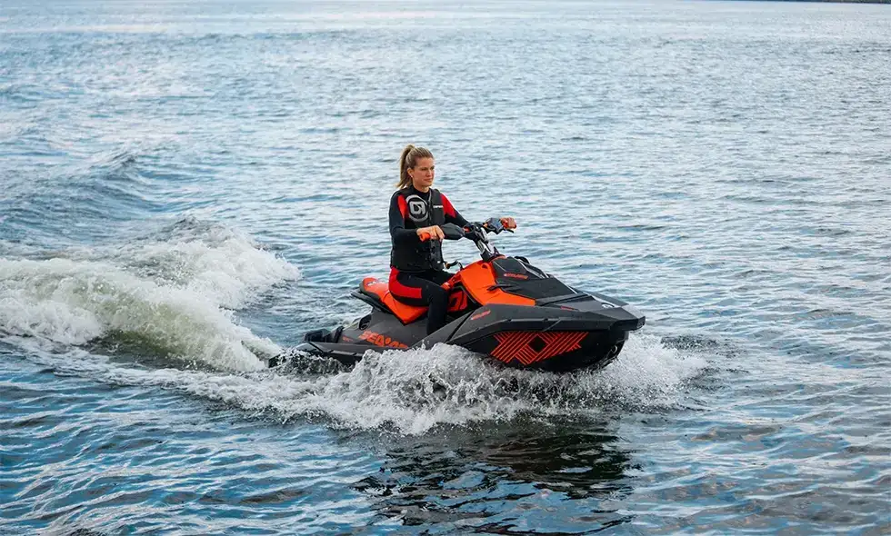 Person som kör en svart och röd vattenskoter