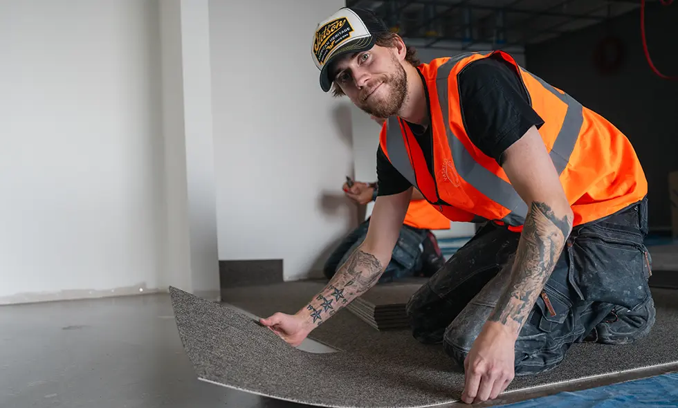 Glad man som lägger golv